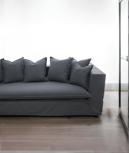 Gray sofa with decorative pillows in a minimalistic room. Paris Collection Sofa – Classic Elegance Reimagined | Vella Concept