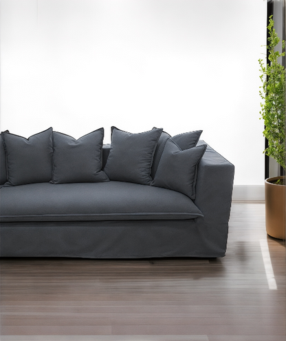 Gray sofa with decorative pillows in a modern living room setting. Paris Collection Sofa – Classic Elegance Reimagined | Vella Concept
