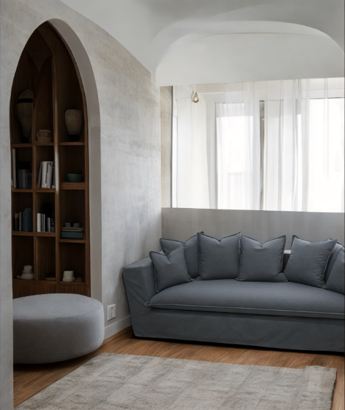 Modern living room with a gray sofa and bookshelf. Paris Collection Sofa – Classic Elegance Reimagined | Vella Concept