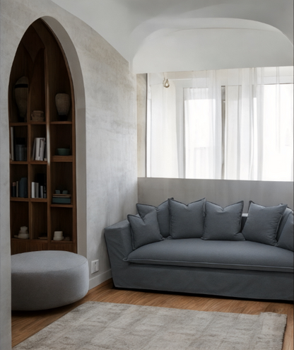 Modern living room with a gray sofa and bookshelf. Paris Collection Sofa – Classic Elegance Reimagined | Vella Concept