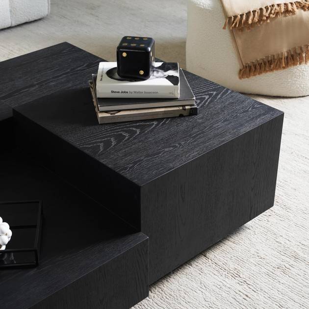 Black coffee table with decorative items in a living room setting