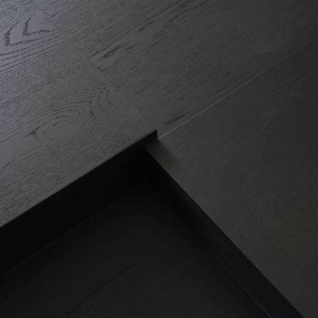 Close-up of dark wood flooring with a visible grain pattern.