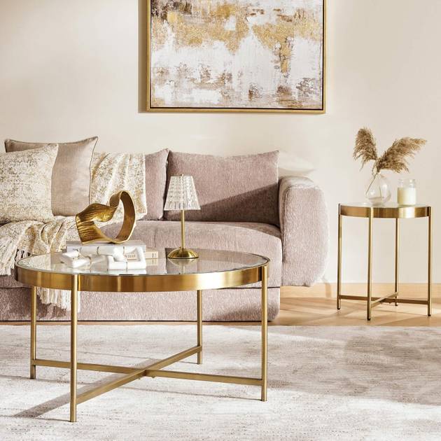 Modern living room with gold coffee table, side table, and abstract art on wall.