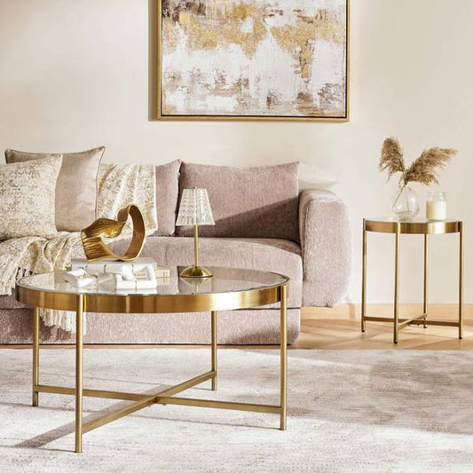 Modern living room with gold coffee table, side table, and abstract art on wall.