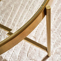 Close-up of a gold-framed mirror on a textured white wall