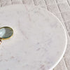 Marble surface with a magnifying glass on a textured gray background- Porada Coffee Table – White Marble Top with Gold Base