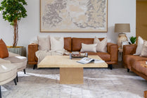 Living room with brown leather sofa, beige armchair, and coffee table.