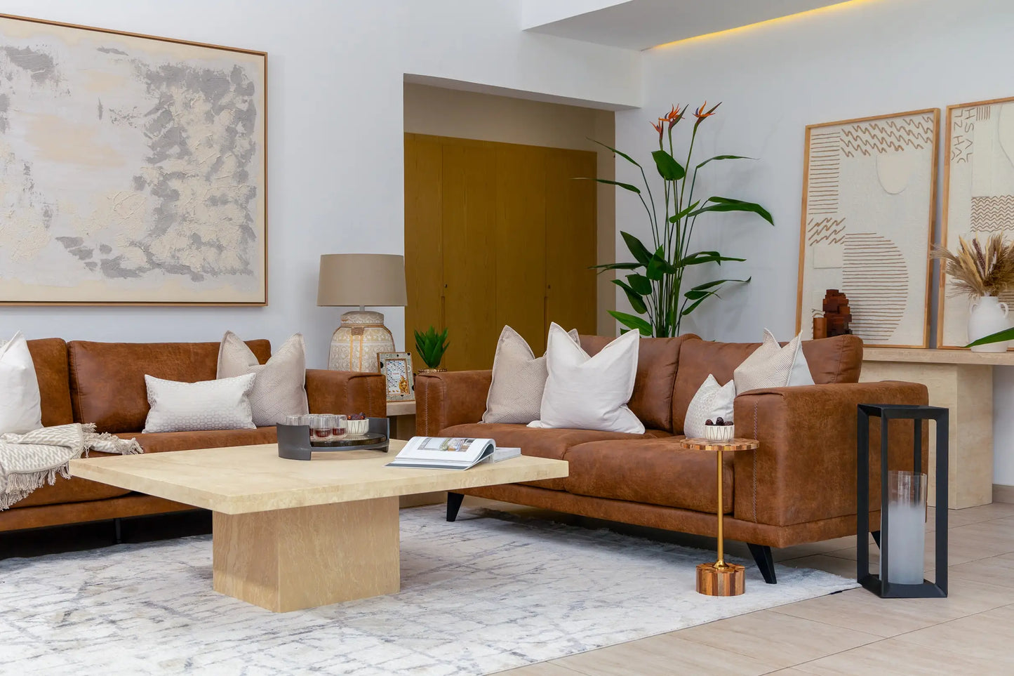 Modern living room with brown leather sofa, wooden coffee table, and decorative elements.