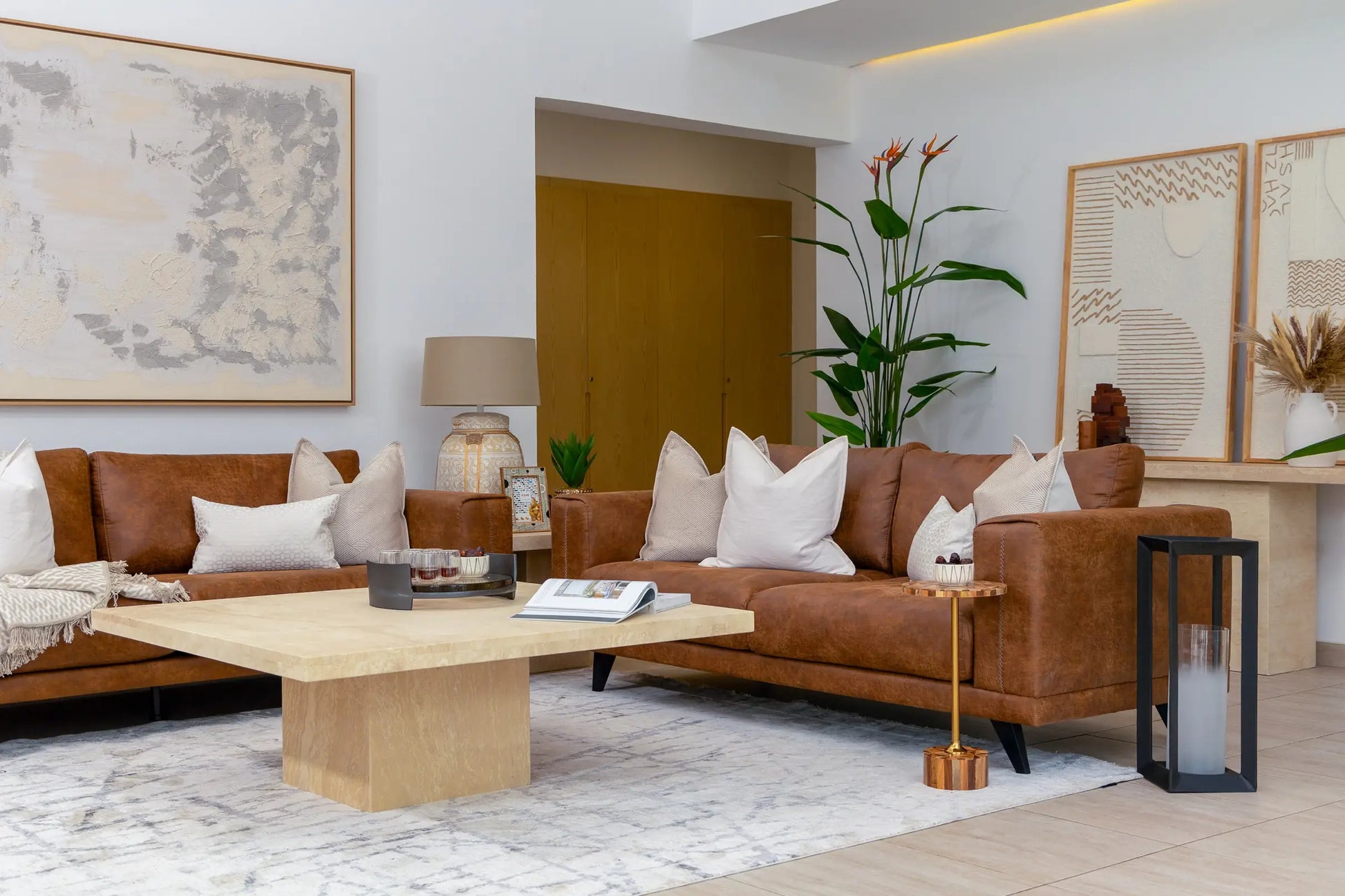 Modern living room with brown leather sofa, wooden coffee table, and decorative elements.