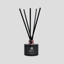 Black diffuser with sticks on a gray background