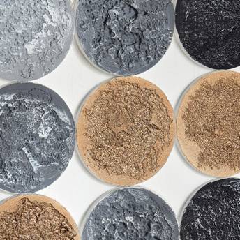 Close-up of round stone tiles in various colors on a white background