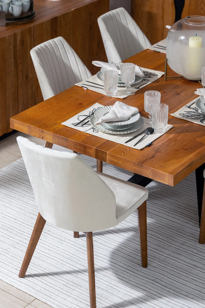 Dining table set with plates, glasses, and cutlery in a modern kitchen.