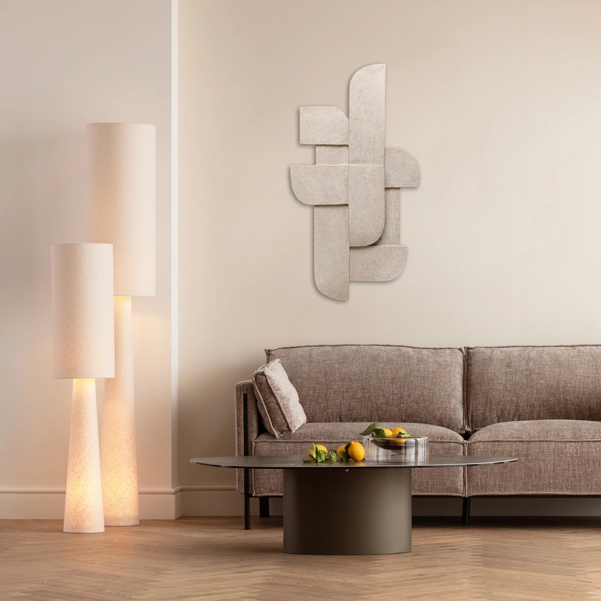 Modern living room with a gray sofa, coffee table, and decorative mirror.