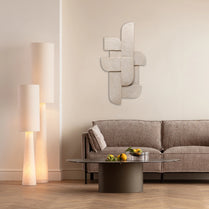 Modern living room with a gray sofa, coffee table, and decorative mirror.