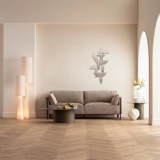 Modern living room with a gray sofa, coffee table, and decorative wall piece.
