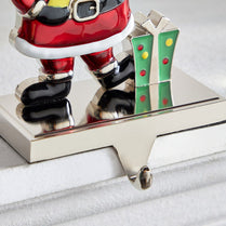 Metallic Santa Claus figurine with a candy cane on a white surface