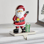 Decorative Santa Claus figure with a gift on a white surface