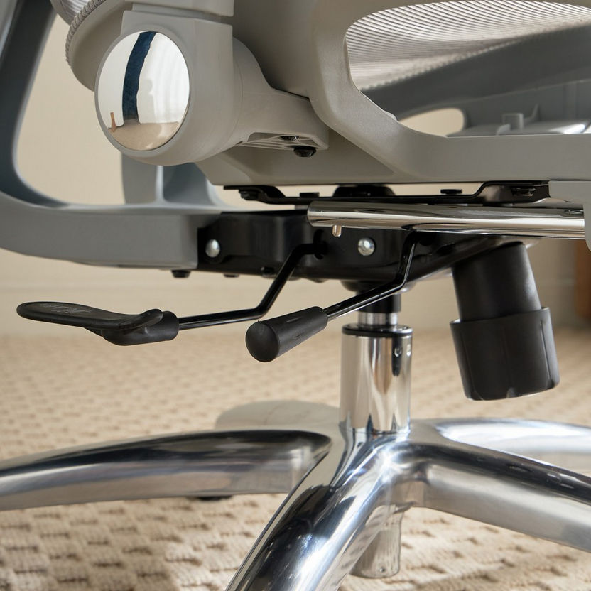 Close-up of an office chair's mechanism on a carpeted floor.