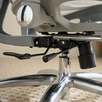 Close-up of an office chair's mechanism on a carpeted floor.