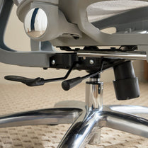 Close-up of an office chair's mechanism on a carpeted floor.