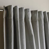 Gray curtains hanging against a neutral background