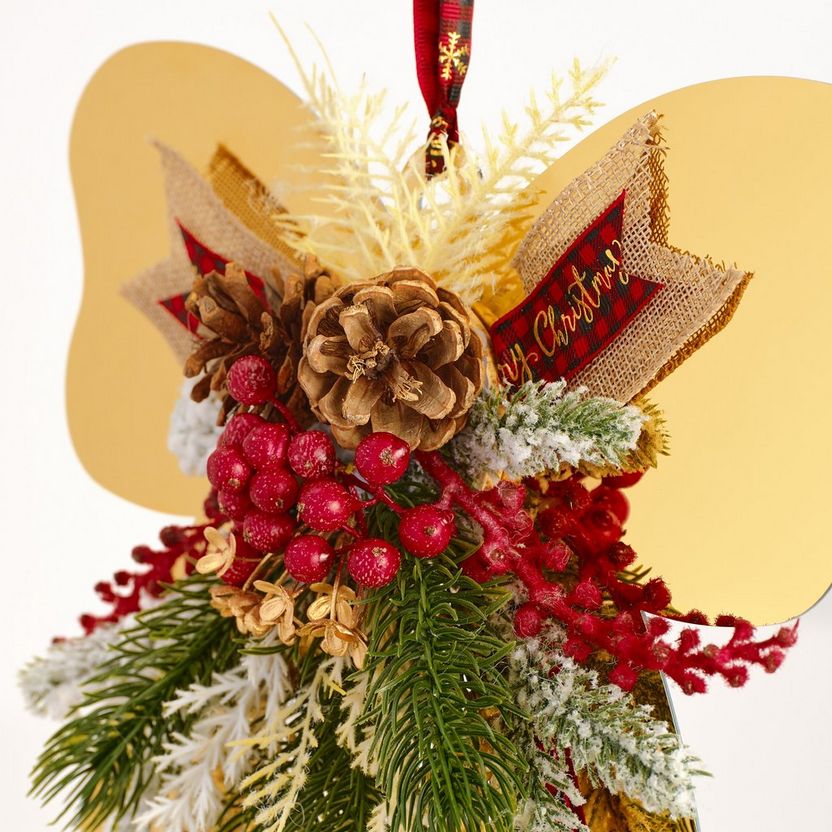Decorative Christmas angel ornament with pinecones, berries, and a red ribbon on a white background