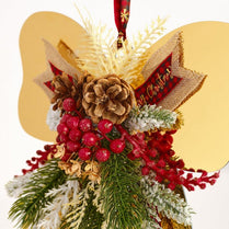 Decorative Christmas angel ornament with pinecones, berries, and a red ribbon on a white background
