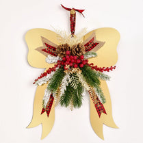 Decorative butterfly ornament with red ribbons, pinecones, and berries on a white background