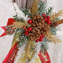 Christmas-themed floral arrangement with pine cones, red berries, and ribbons on a light background