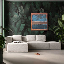 Gray sectional sofa in a room with leaf-patterned wall and abstract painting