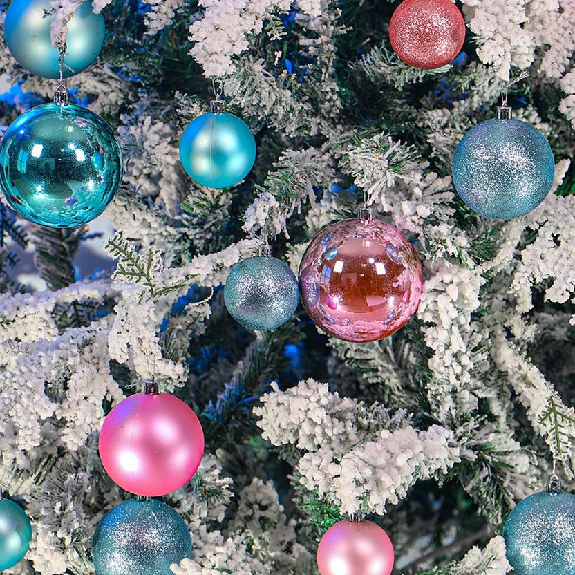 Decorative Christmas tree with colorful ornaments on a snowy branch.