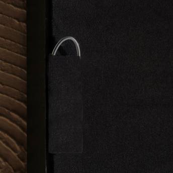 Close-up of a door handle on a black door with a textured brown wall.