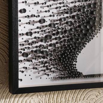 Close-up of a textured black and white wall art piece with a wooden frame.