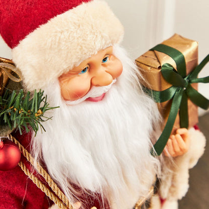 Santa Claus figurine holding a gift with a green ribbon against a neutral background