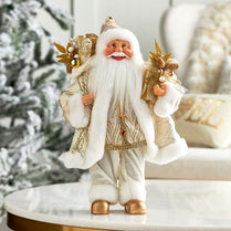 Decorative Santa Claus figure with gold and white attire on a marble surface.