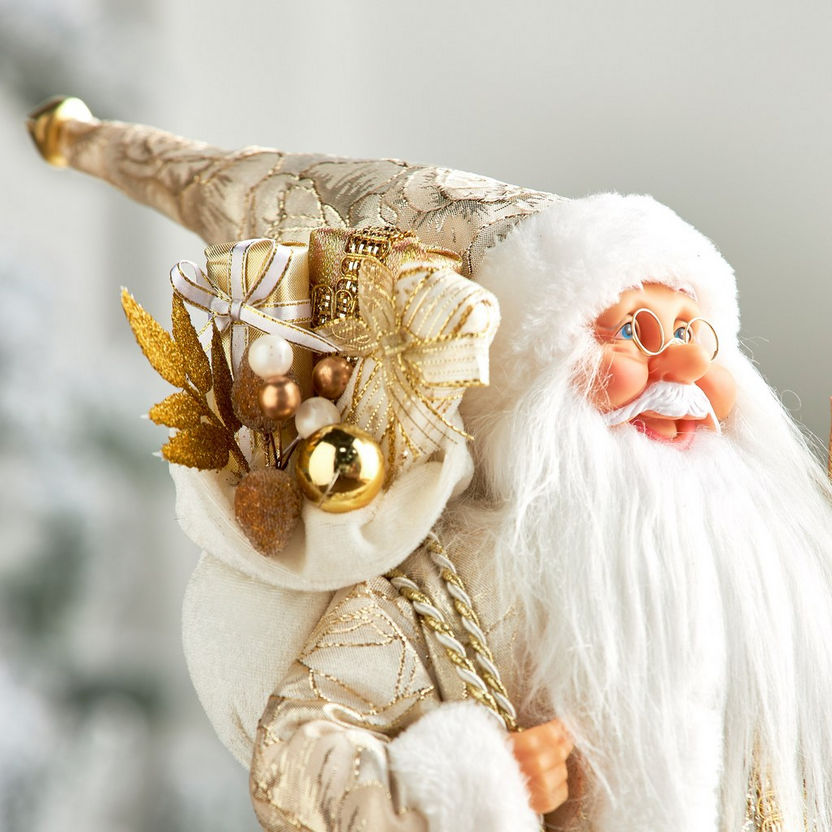 Decorative gnome figure with gold and white accents against a blurred background