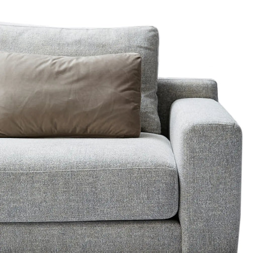 Gray sofa with a brown pillow on a white background