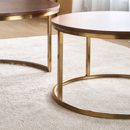 Two round wooden tables with gold metal bases on a light-colored rug.
