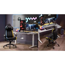 Gaming desk setup with chairs, monitors, and gaming equipment in a room.