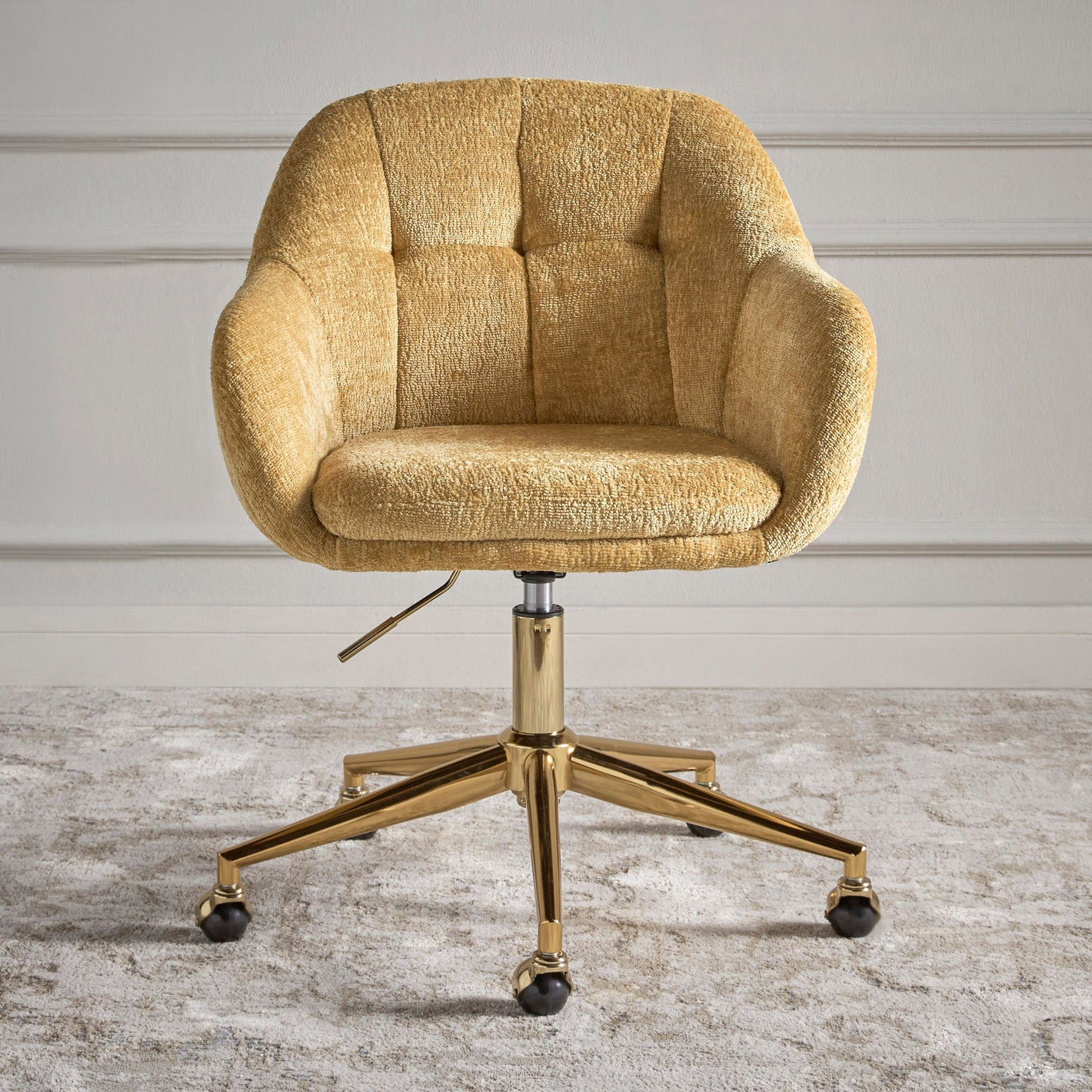 Gold textured office chair on a wooden floor with a neutral wall background