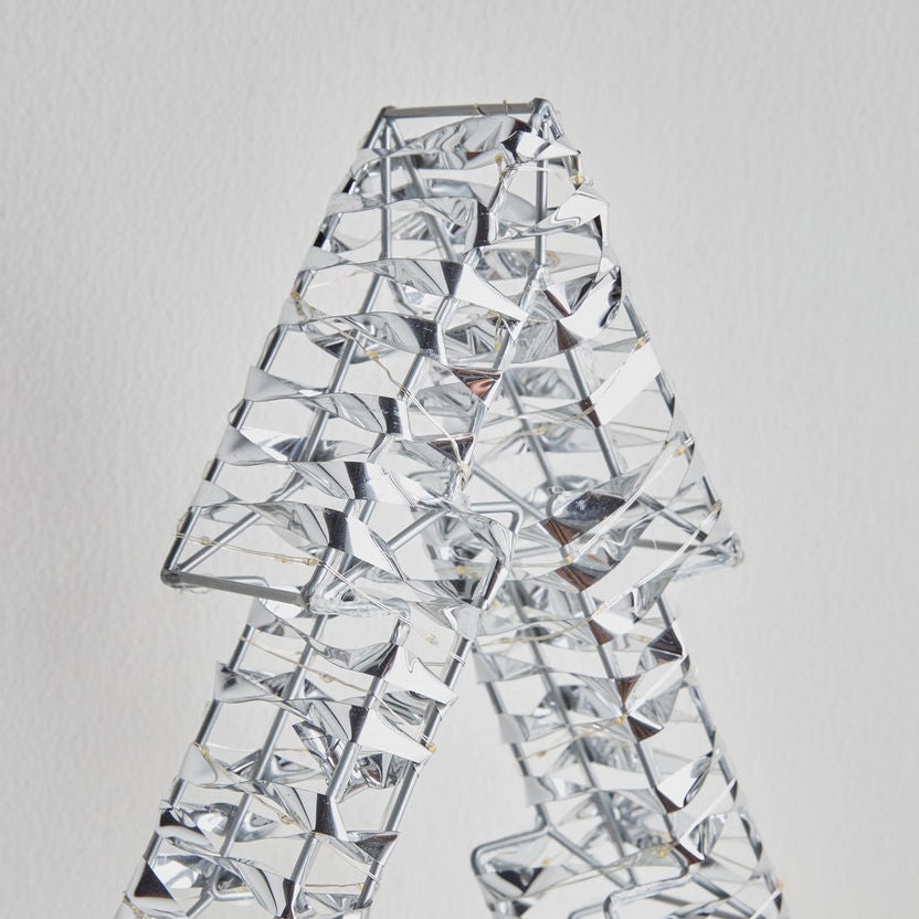 Crystal decorative item shaped like a person on a light gray background