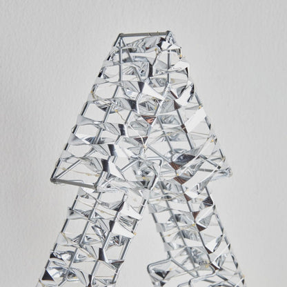 Crystal decorative item shaped like a person on a light gray background
