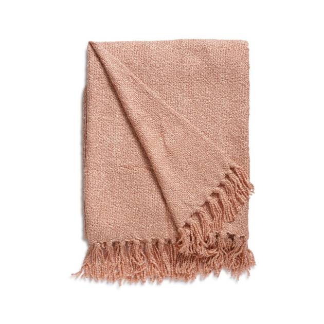 Pink textured throw blanket with fringes on a white background