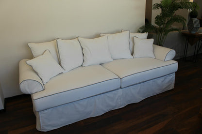 White sofa with white cushions in a room with a plant and table. Venice Collection Sofa – Deep Comfort for Modern Living | Vella Concept