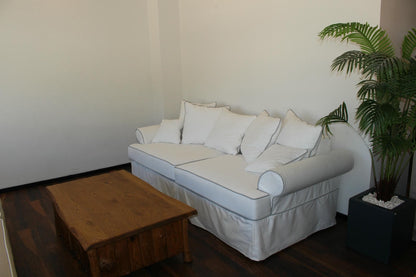 Living room with a white sofa, wooden coffee table, and a plant. Venice Collection Sofa – Deep Comfort for Modern Living | Vella Concept