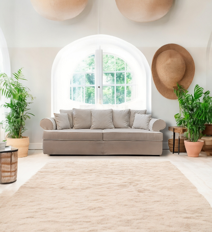 Beige sofa in a bright living room with plants and a hat on the wall - Venice Collection Sofa – Deep Comfort for Modern Living | Vella Concept