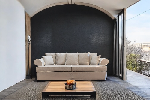 Beige sofa on a patio with a coffee table and outdoor view - Venice Collection Sofa – Deep Comfort for Modern Living | Vella Concept