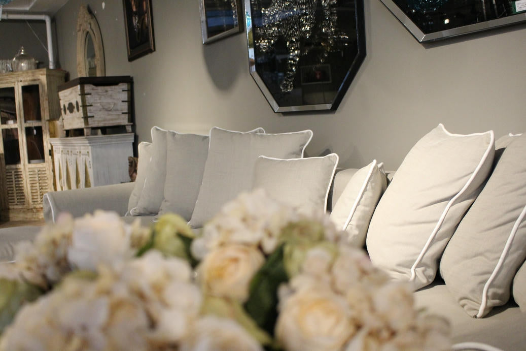 Living room with a gray sofa and decorative flowers in the foreground - Venice Corner Collection Sofa – Spacious Comfort with Modern Style | Vella Concept