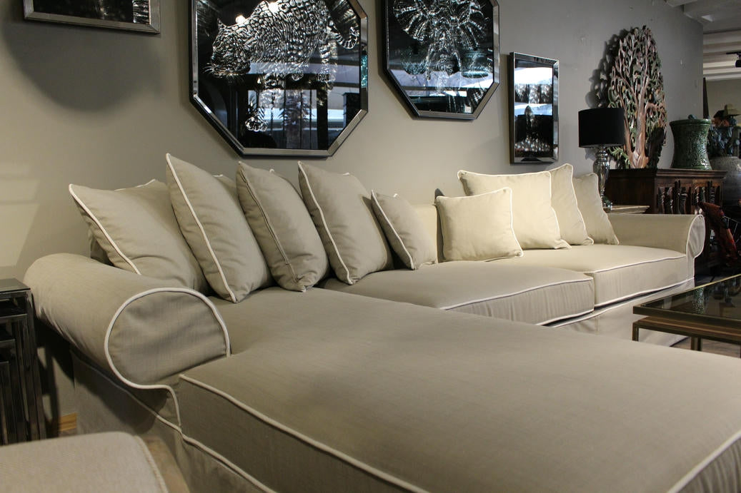 Beige sectional sofa with decorative pillows in a room with mirrors and a coffee table. Venice Corner Collection Sofa – Spacious Comfort with Modern Style | Vella Concept