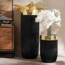 Two black vases with gold accents on a neutral background